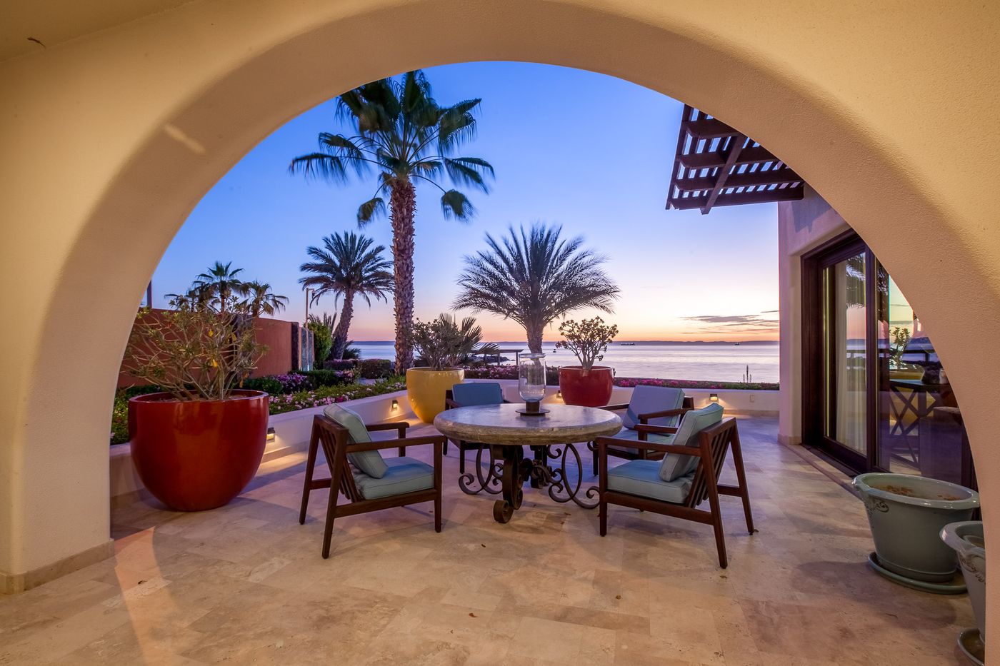 Arco de la terraza que enmarca el mar al atardecer