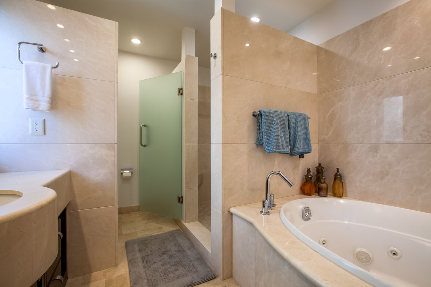El baño, con tina y regadera de cristal.