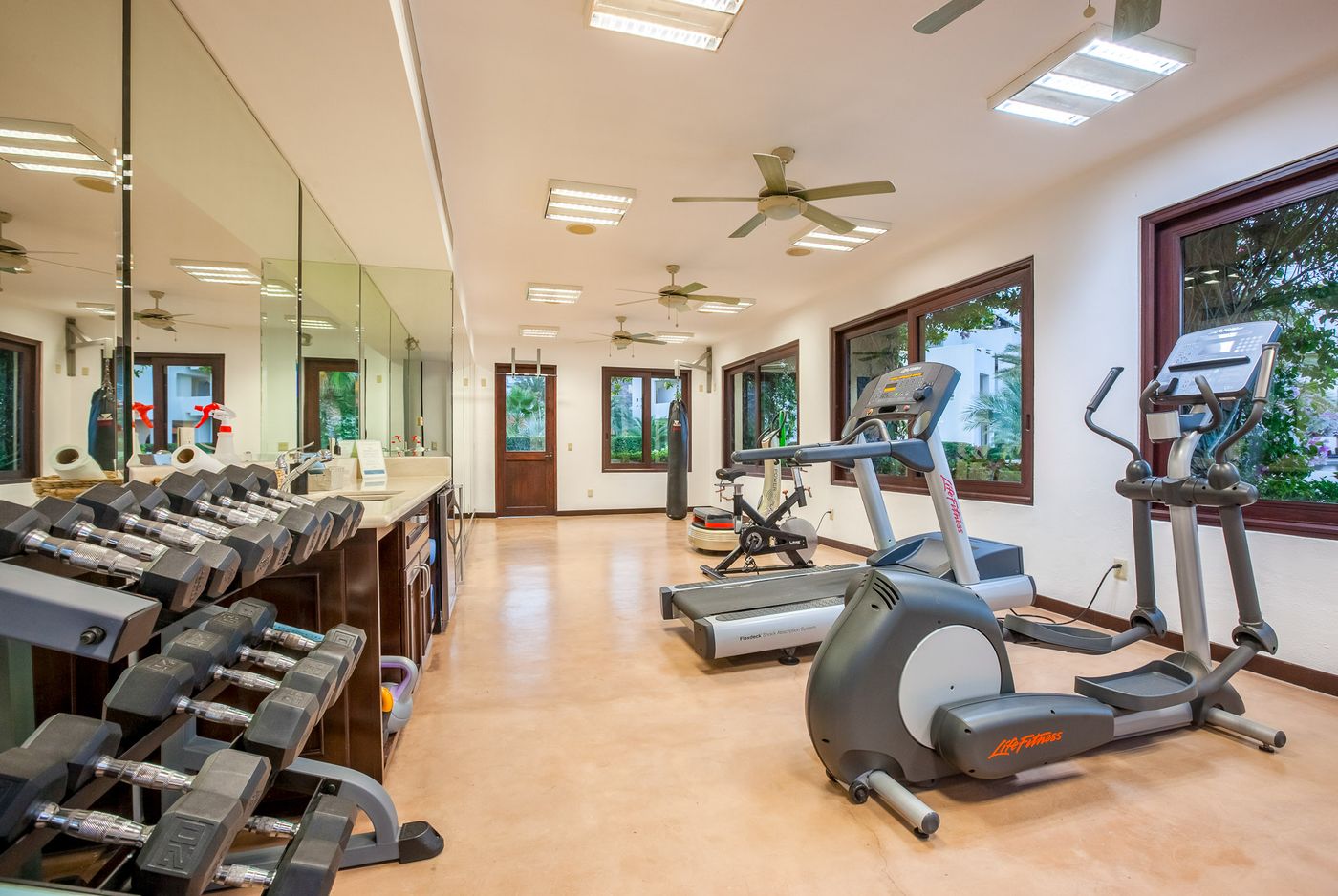Gimnasio del conjunto, con espejos y aparatos frente a las ventanas